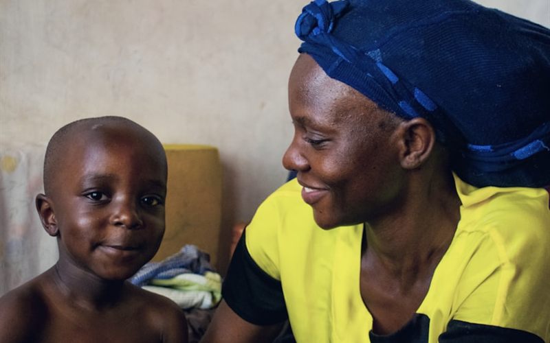 A community health worker with a young child in her care