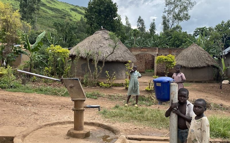 Children beside a hand pump in a village