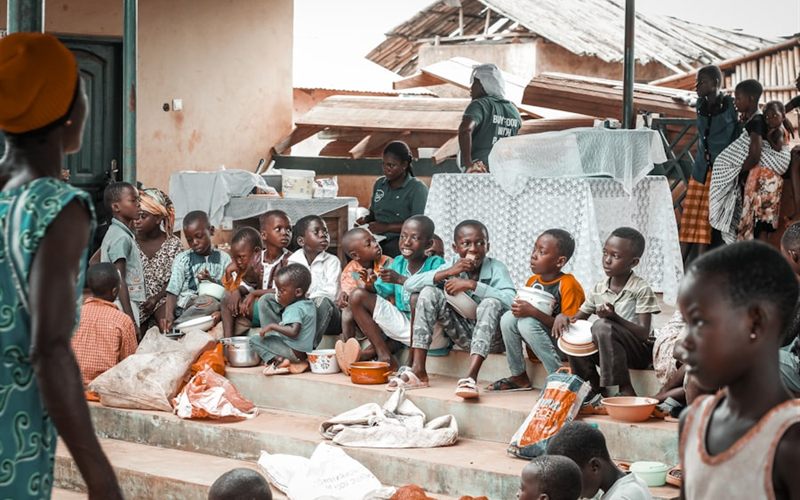 Children eating a meal together outside a community building